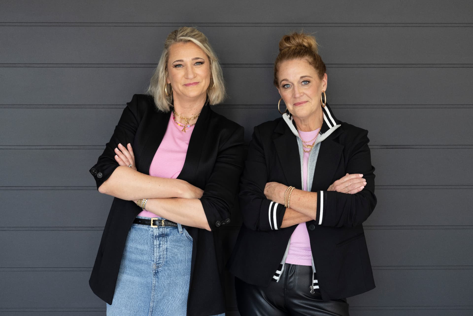 Kristen Campbell and Kristin Argento wearing black blazers and pink tops